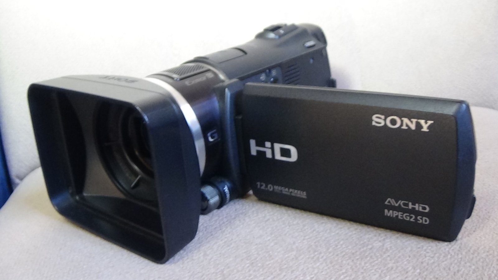 Filmadora compacta Sony HXR-MC50 preta vista de lado e tela LCD aberta